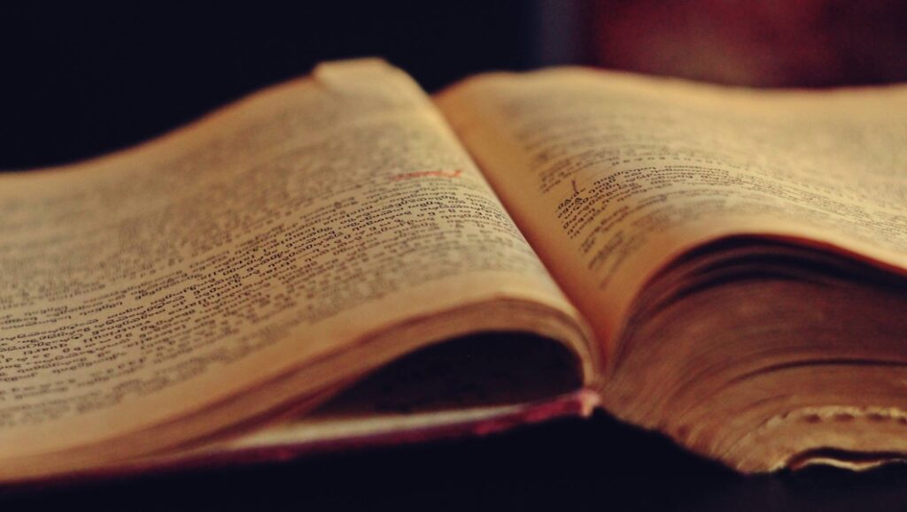 Close-up of an open vintage book with densely packed text, pages yellowed with age, evoking reflection, philosophical depth, and timeless inquiry